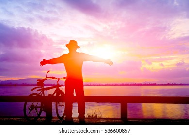 Silhouette man and bike relaxing with sun flare effect on sunrise time at beach. - Shutterstock ID 536600857