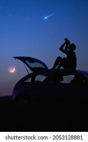 Silhouette of a man, car and countryside under the starry skies.