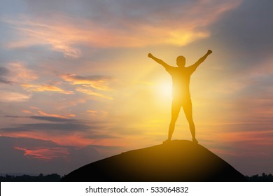 Silhouette of Man Celebration Success Happiness on a mountain top Evening Sky Sunset Background, Sport and active life Concept.