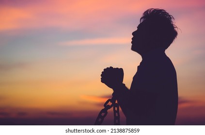 Silhouette man with chain Freedom, Worship and Pray.Repent of wrong doing.Prisoner with break chain power of prayer sunset background.Pray faith hope.Forgive revival.Sacrifice and .Juneteenth.African.