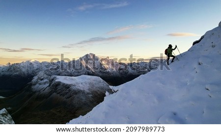 silhouette of a man climbing a mountain in winter