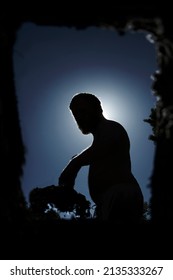 Silhouette Of A Man Digging A Grave