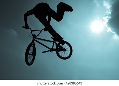 Silhouette Of A Man Doing An Extreme Jump With A Mountain Bike. BMX.