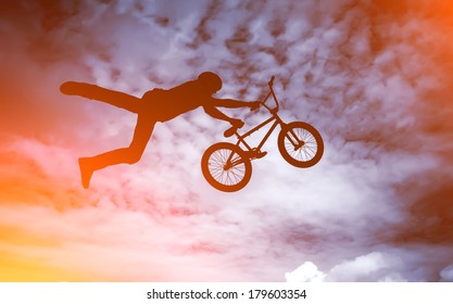 Silhouette Of A Man Doing An Jump With A Bmx Bike Against Sunshine Sky. 