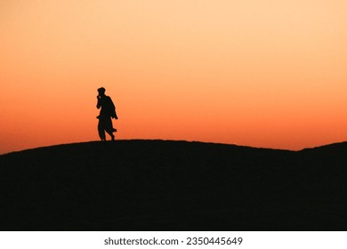 A silhouette of a man enjoying a cigarette in the evening in Rajasthan. - Powered by Shutterstock - Get 15% off with code: PIKWIZARD15