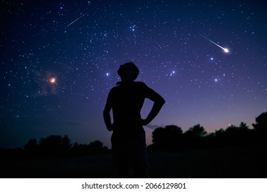 Silhouette of a man enjoying countryside under the starry skies.