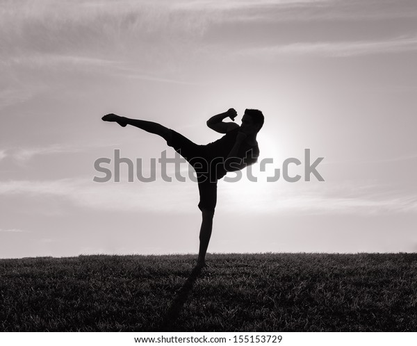 Silhouette of man\
exercising thai\
boxing