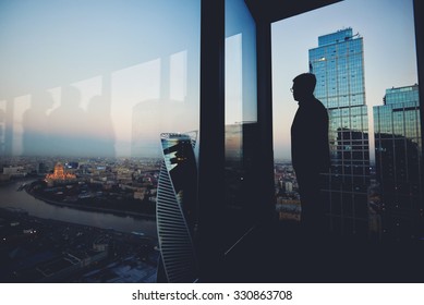 Silhouette of a man financier think about something while standing near office window background with copy space for your text message or advertising content, young male thoughtful rest after briefing - Powered by Shutterstock