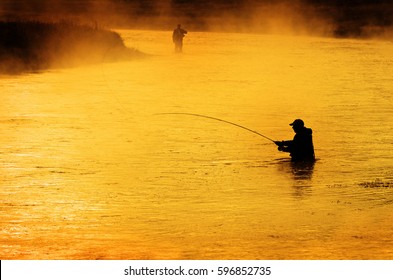 Silhouette of Man Flyfishing Fishing in River