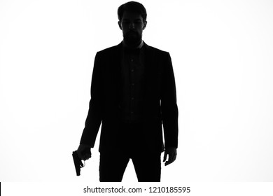silhouette of a man with a gun on a light background                        
