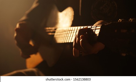 Silhouette of a man in a hat against the light, backlit guitar concert, performance with contrast - Powered by Shutterstock