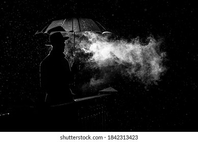 silhouette of a man in a hat under an umbrella at night in the rain in the city in the old crime Noir style