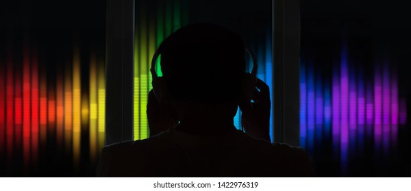 Silhouette Of Man In Headphones Conducting Music On Music Equalizer Background