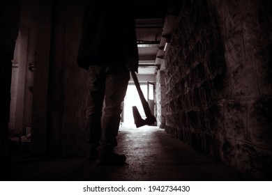 Silhouette Of Man Holding Axe. Hatchet In Arm In Dark Hallway. Scary Homicide Scenes