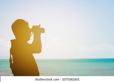 Silhouette Of Man Holding Binoculars To Watching At The Sea