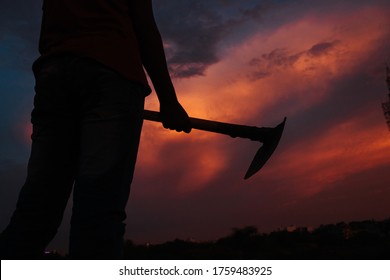 Silhouette Of A Man Holding Plough In His Hand