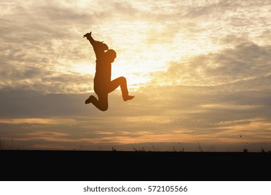 A silhouette of man  jumping in the sunset background.
