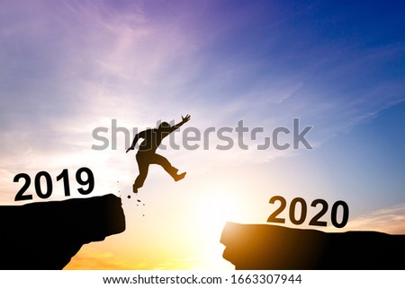 Silhouette of man jumping through the gap on sunset background.challenge for across barrier to achievement or successful in business concept