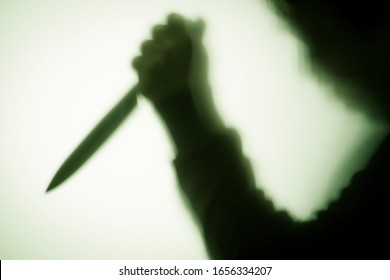 Silhouette Of A Man With A Knife In His Hand Through Frosted Glass, Killer Or Burglar