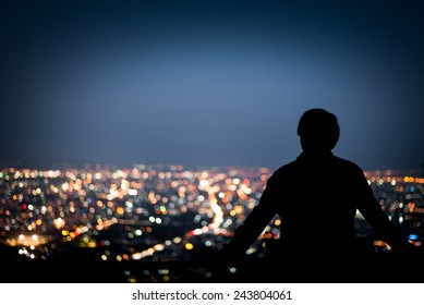 Silhouette of man looking above the city in the night - Powered by Shutterstock