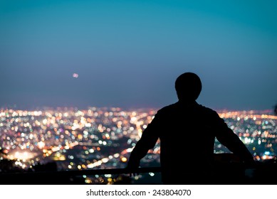 Silhouette of man looking above the city in the night - Powered by Shutterstock