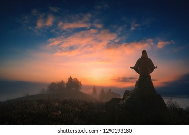 Silhouette Of Man Meditating In Sitting Yoga Position On Cliff Above The Misty Valley. Zen, Meditation, Peace. Instagram Stylisation.