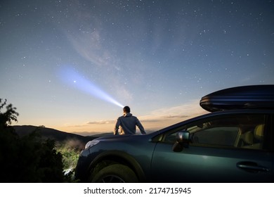 Silhouette of man at offroad car with head flashlight on background of very beautiful night starry sky after sunset. Freedom and travel by car concept - Powered by Shutterstock