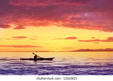 Silhouette Of Man On Kayak With Sunset