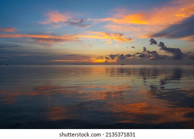 Silhouette of a man on a paddleboard during beautiful sunset on the water of the sea on the island of Koh Phangan, Thailand. Active rest on the sea