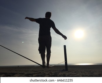 Silhouette Of A Man On A Slack Line