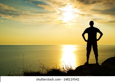 Silhouette Of Man On The Sunset On Rock