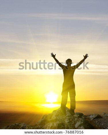 silhouette of man on the sunset on top of the mountain.