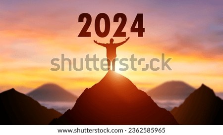 Silhouette of man on the top of the mountain with the beginning of New Year 2024 number background.