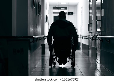 Silhouette of man on wheelchairs in corridor of hospital - Powered by Shutterstock