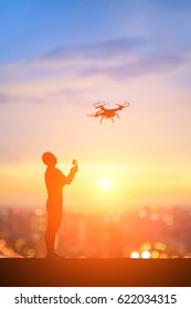 silhouette of man play drone with sunset
