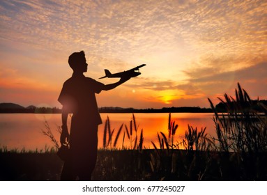 silhouette man play RC Airplane when the sunset.