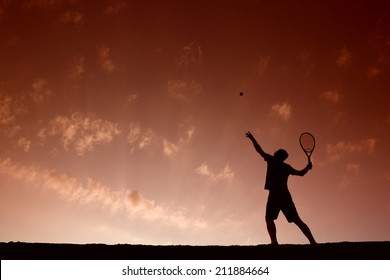 Silhouette of man playing tennis