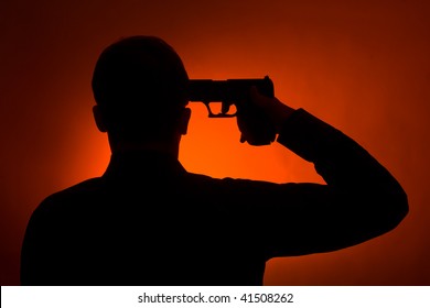 silhouette of the man pointing gun to his head, ready to commit suicide