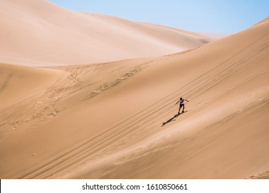 silhouette of man practice sandboarding in the desert of Peru. - Powered by Shutterstock