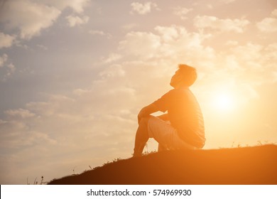 Silhouette of man praying over beautiful sky background