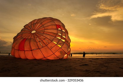 Silhouette Of Man Is Preparing Para Sailing At The Sunset Beach In Thailand