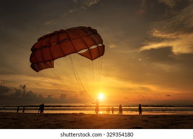 Silhouette Of Man Is Preparing Para Sailing At The Sunset Beach In Thailand