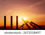 Silhouette of man pushing rectangular blocks down to stop the dominoes with background of light sky sunset. Concept of prevention, and risk management.