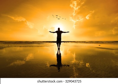 Silhouette Of Man Raising His Hands Or Open Arms When Sun Rising Up