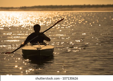 Silhouette of a man rowing in the canoe - Powered by Shutterstock