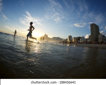 Silhouette of man running into the sunset surf Ipanema Beach Rio de Janeiro Brazil