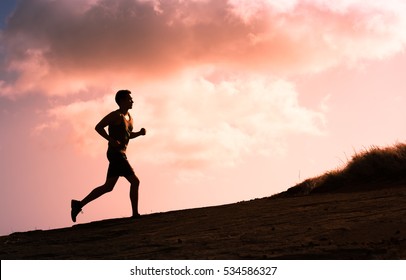 Silhouette Of Man Running Outdoors.