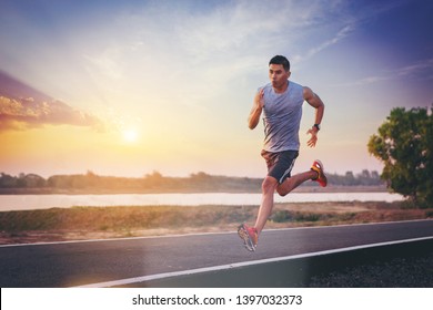 Silhouette of man running sprinting on road. Fit male fitness runner during outdoor workout with sunset background - Shutterstock ID 1397032373