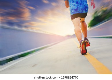 Silhouette of man running sprinting on road. Fit male fitness runner during outdoor workout with sunset background. With motion blur speed zoom - Shutterstock ID 1598924770