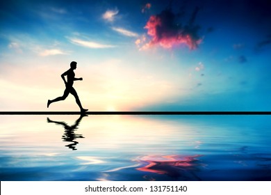 Silhouette of man running at sunset. Water reflection - Powered by Shutterstock